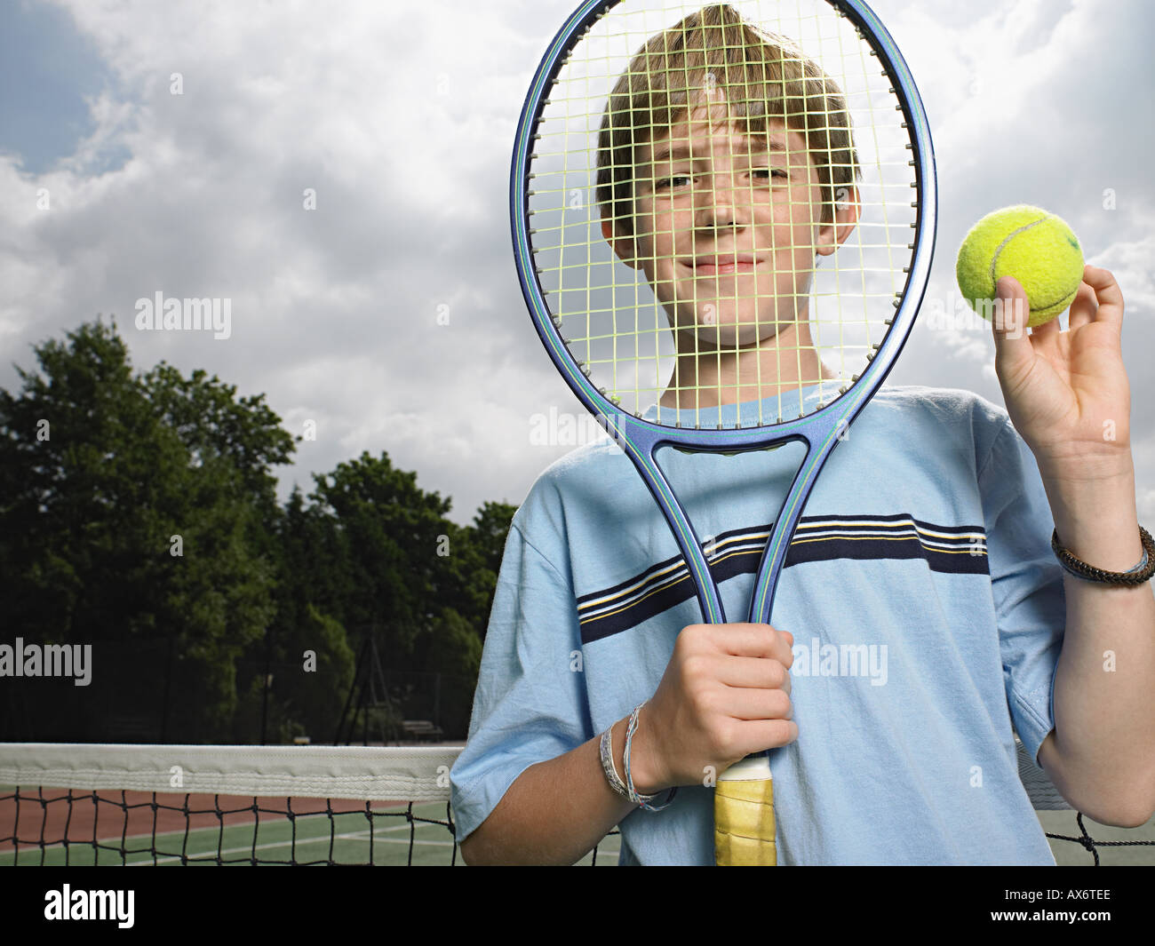 Niño sosteniendo la bola y la raqueta de tenis Foto de stock