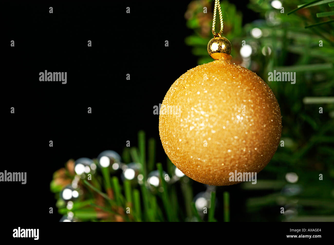 Decoración de Navidad árbol colgando de baubel oro contra el fondo negro Foto de stock
