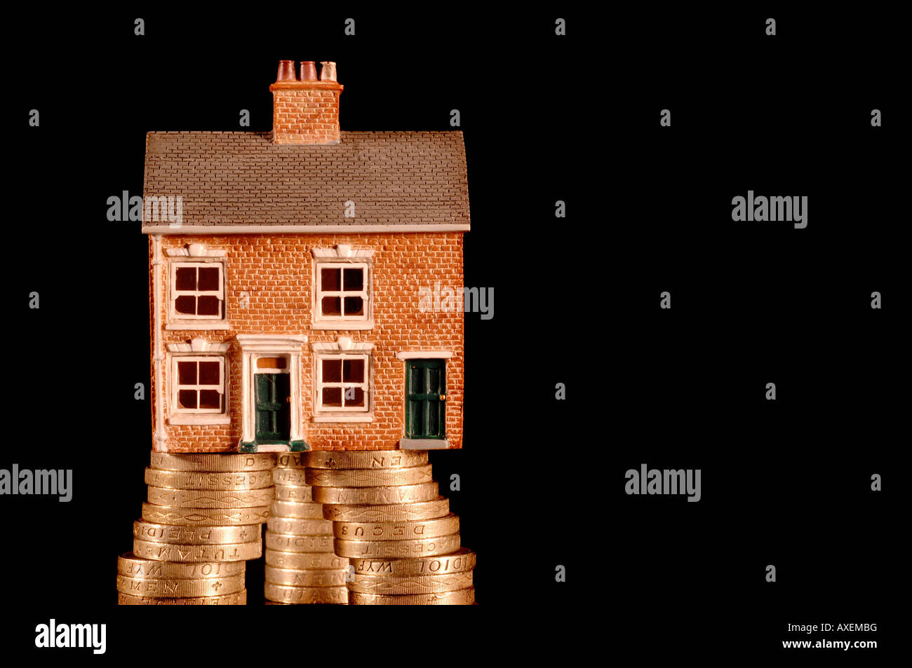 Una casa hundido en deuda con British Pound monedas Foto de stock