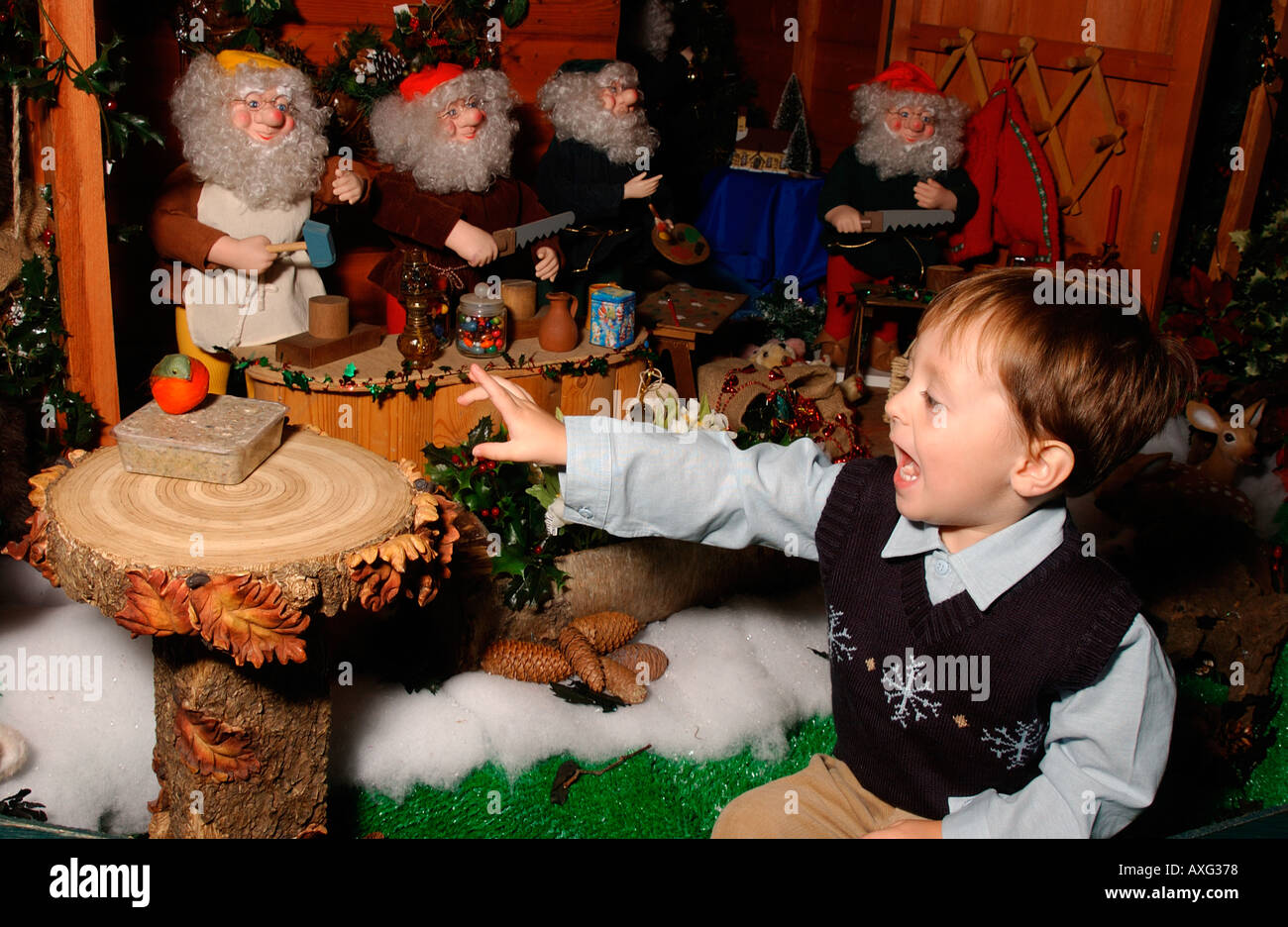 Joven jugando en santa's grotto en Navidad Foto de stock