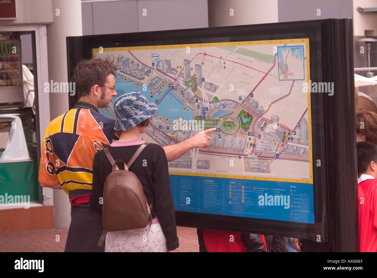 Dos turistas que utilizan un mapa de directorio de la ciudad en Sydney, Australia para encontrar su camino Foto de stock