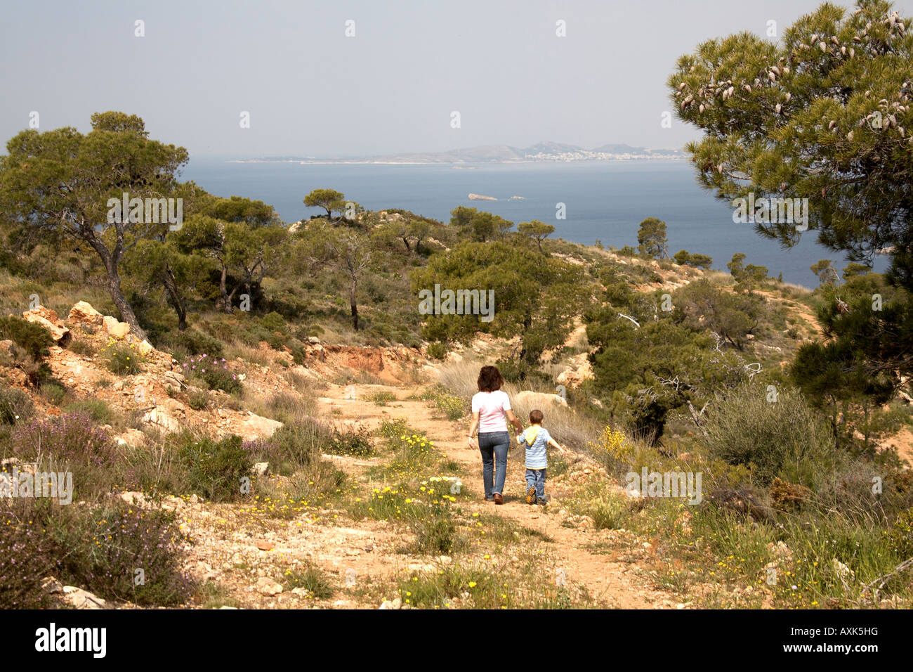 Joven niño caminando con madre mujer mar en verde reserva natural del área de conservación o Atiki Saronida Attica Grecia K Foto de stock
