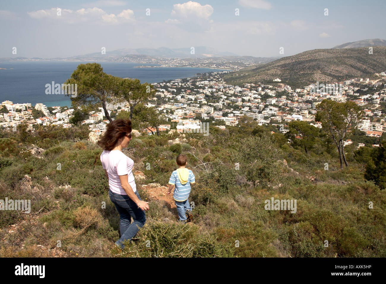 Joven niño caminando con madre mujer mar en verde reserva natural del área de conservación o Atiki Saronida Attica Grecia K Foto de stock