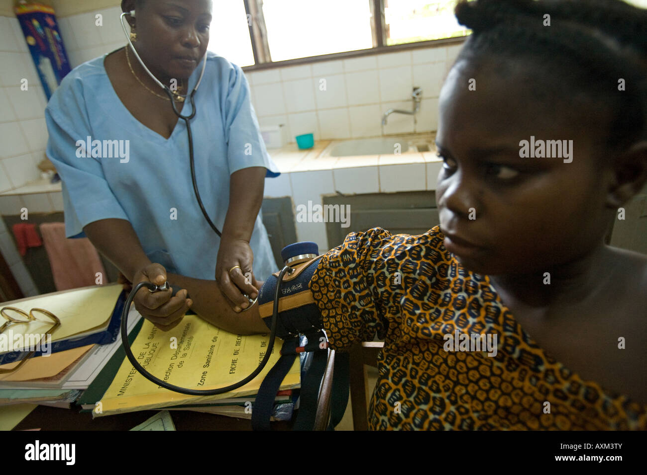 Un trabajador de la salud comprueba la presión arterial de una mujer embarazada Foto de stock