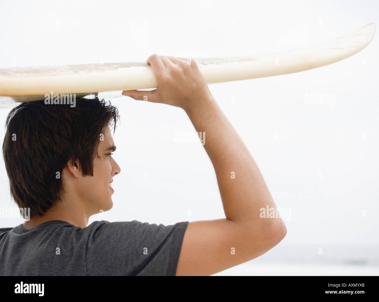 El hombre lleva las tablas de surf en la cabeza. Foto de stock