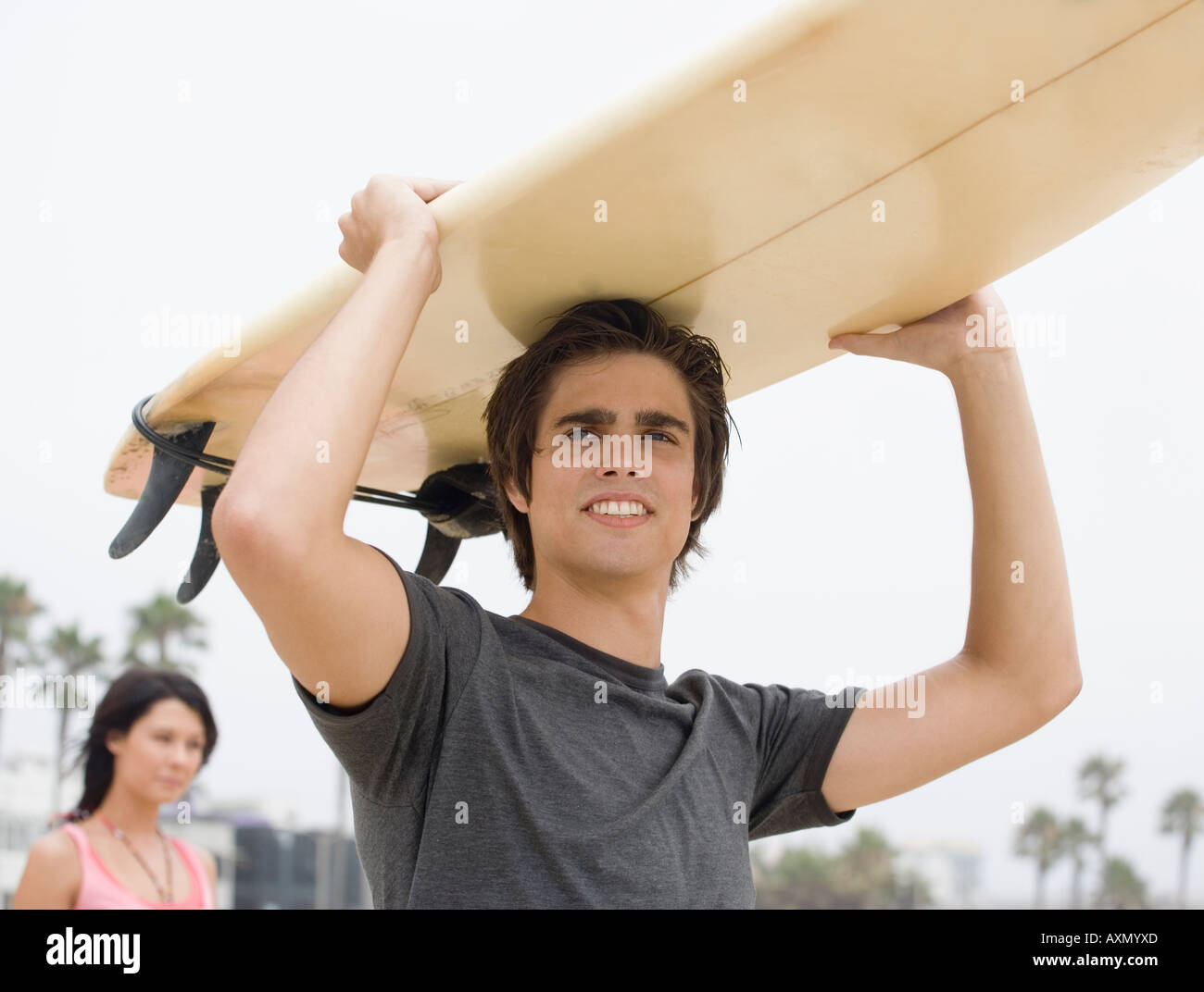 El hombre lleva las tablas de surf en la cabeza. Foto de stock