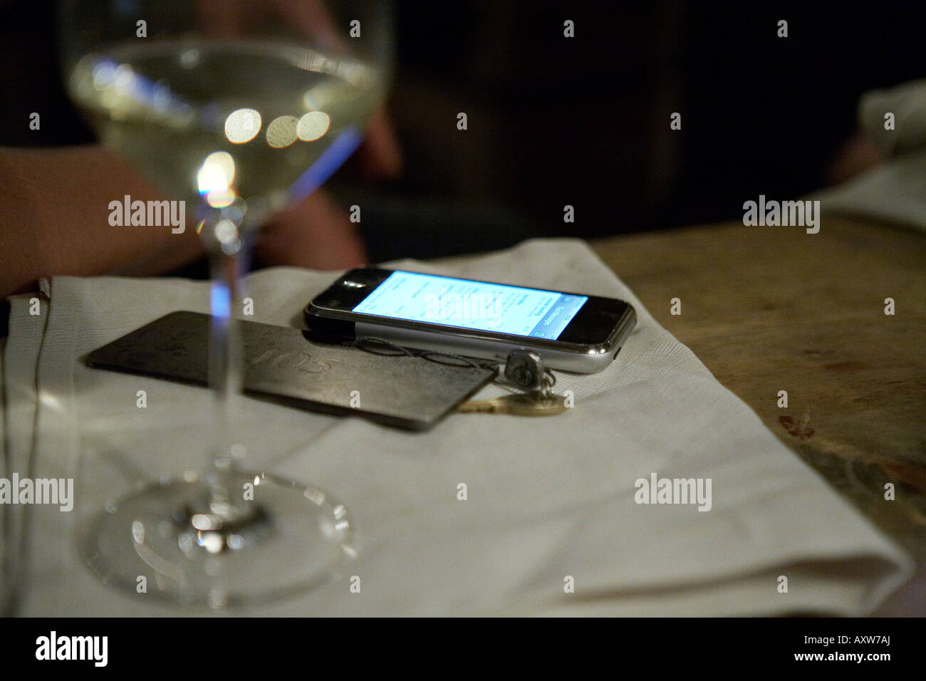 Apple I-phone con la llave de la habitación y una copa de vino. Foto de stock