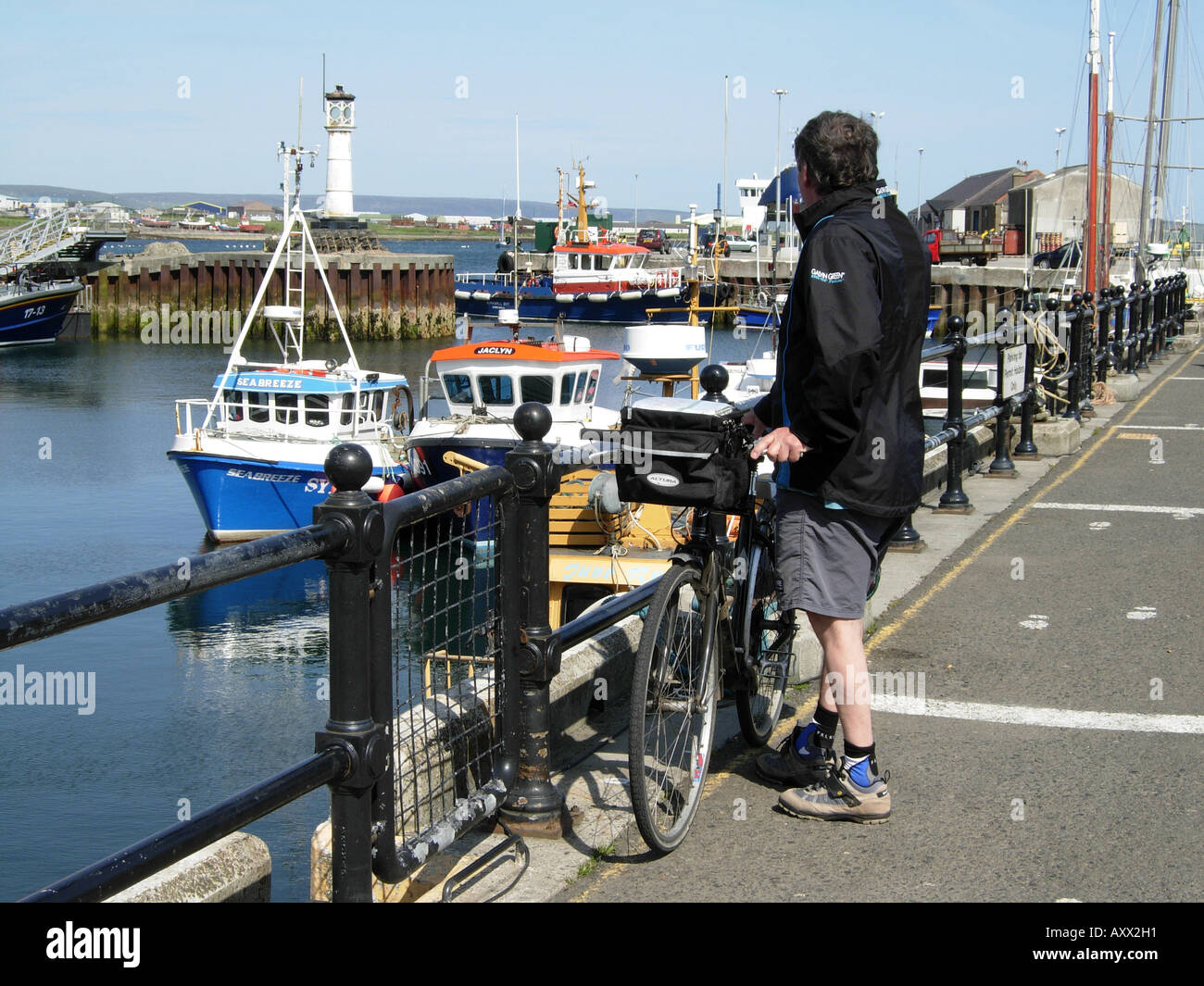 Ciclista de pie en el muelle de Kirkwall puerto en la isla de Orkney Foto de stock