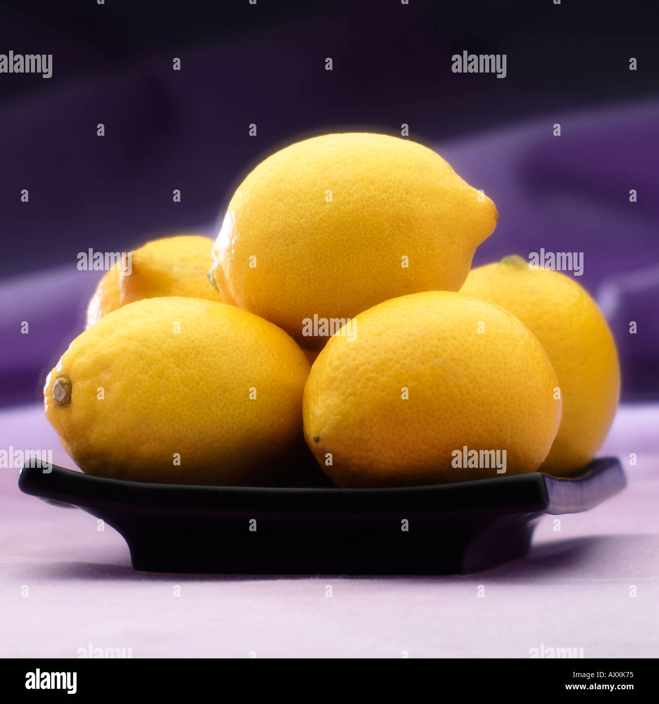 Varios limones en placa negra Foto de stock