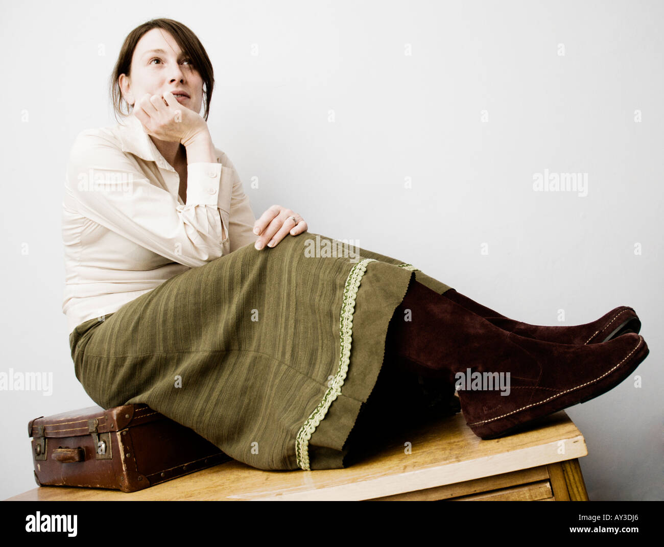 Una cuidadosa buscando mujeres caucásicas sentada sobre una maleta Foto de stock
