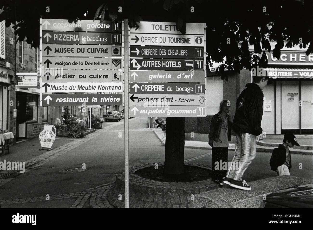 En blanco y negro de varios restaurante del hotel y el museo signos en una ciudad francesa Foto de stock
