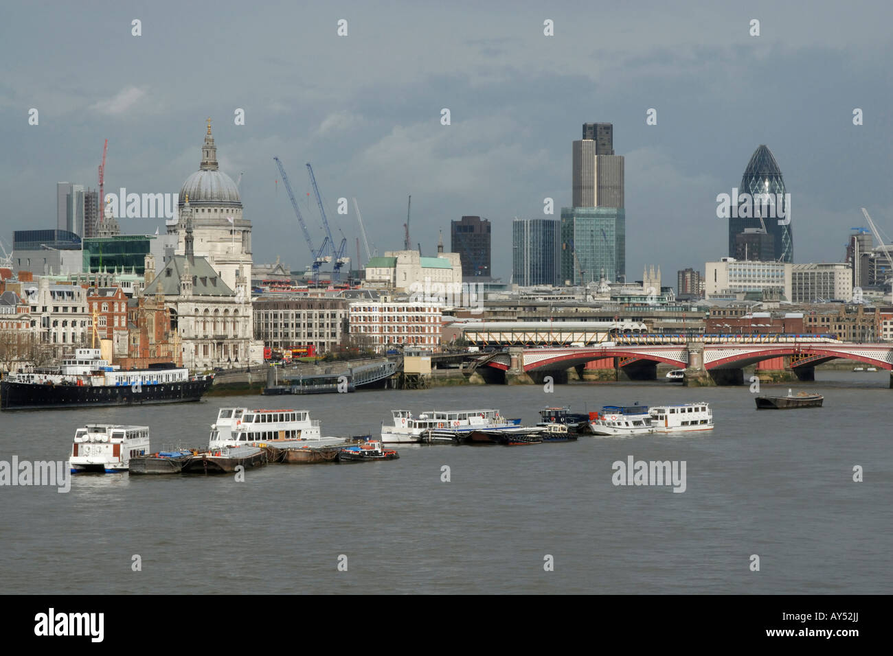 Vista de la ciudad de Londres (milla cuadrada) cruzando el río Támesis, con amarran embarcaciones turísticas en primer plano, Londres, Inglaterra Foto de stock