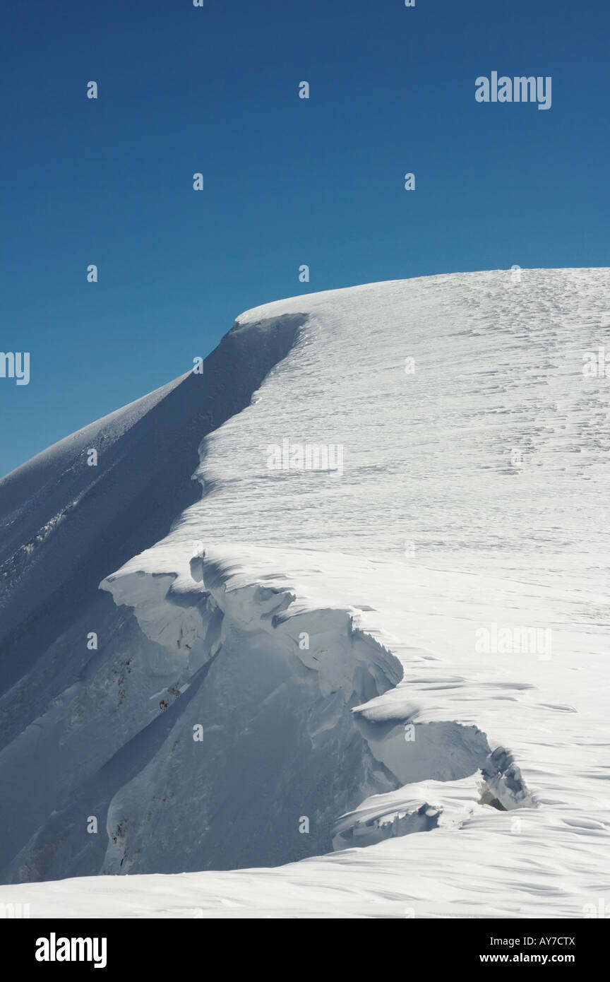 Montaña invernal con saliente de nieve sobre fondo de cielo azul de tapas Foto de stock