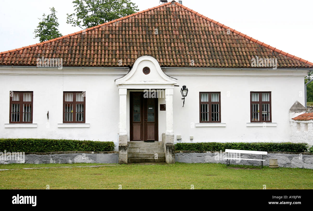 Casa blanca con techo de tejas rojas, ventanas en ambos lados