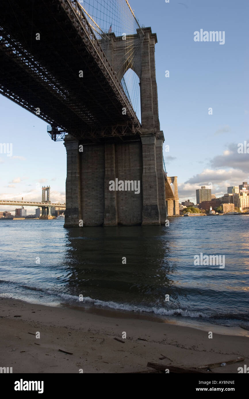 Playa de arena bajo el puente de Brooklyn Foto de stock