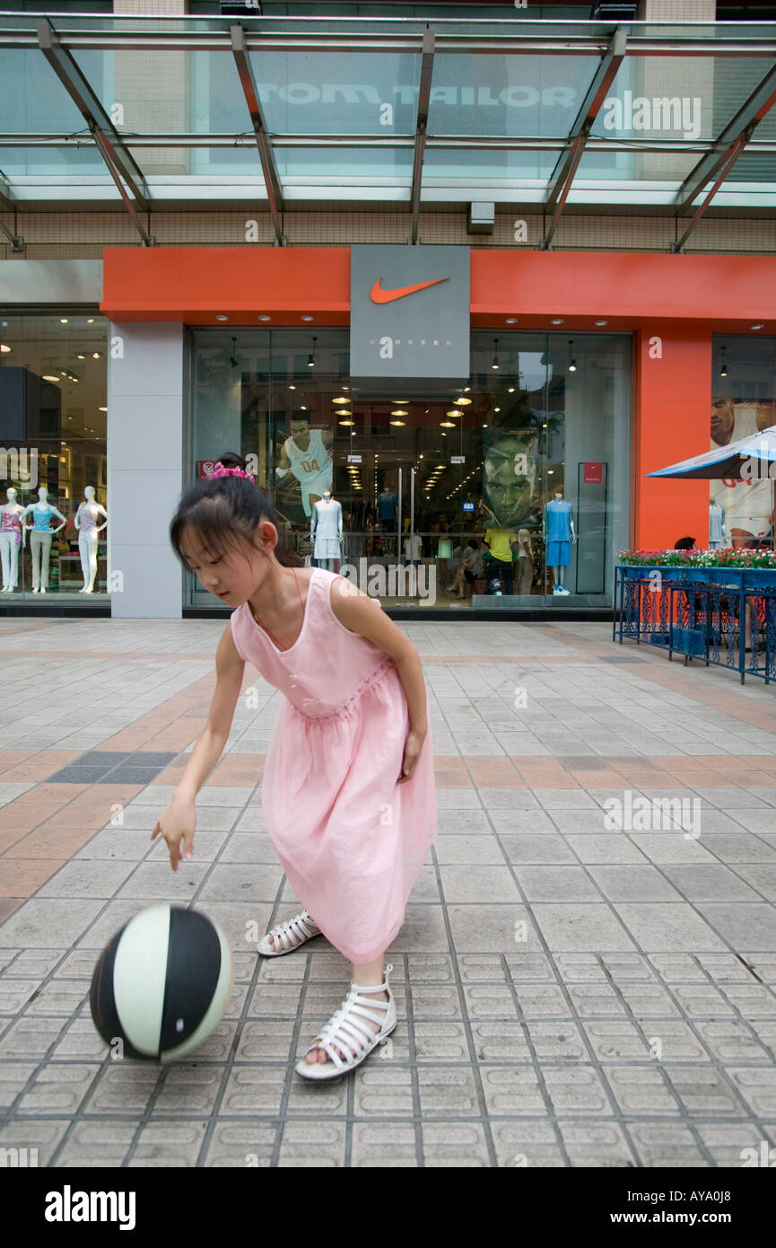 Asia China Beijing niñas juegan al baloncesto en la parte delantera de la  tienda Nike a lo largo de la calle peatonal en Dong una plaza Fotografía de  stock - Alamy