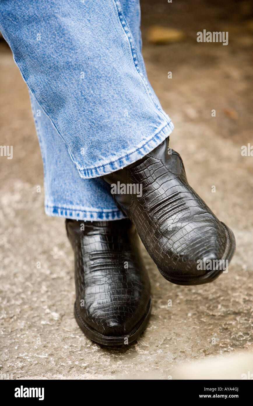 Cerca de los pies del hombre en blue jeans y botas vaqueras Fotografía de  stock - Alamy