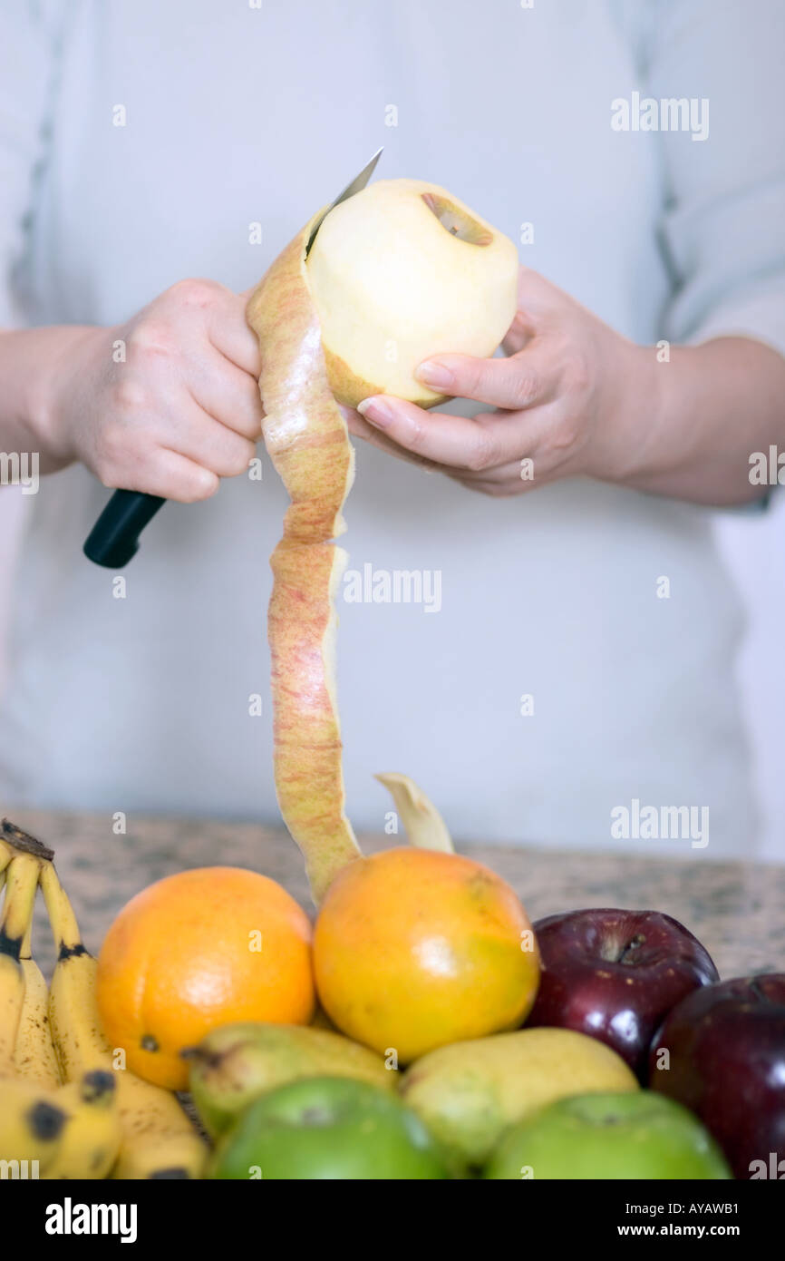 Mujer pelando fruta Stock Photo