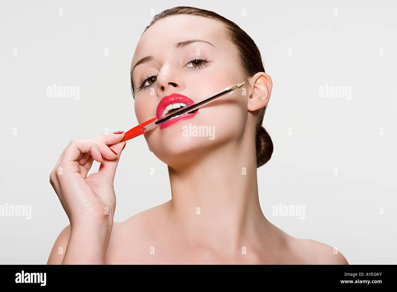 Mujer con un lápiz en la boca Fotografía de stock - Alamy