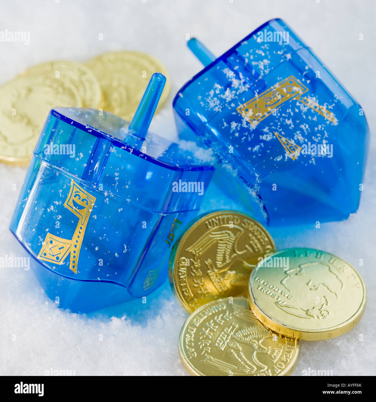 Cerca de Hanukkah monedas y dreidels en la nieve Foto de stock