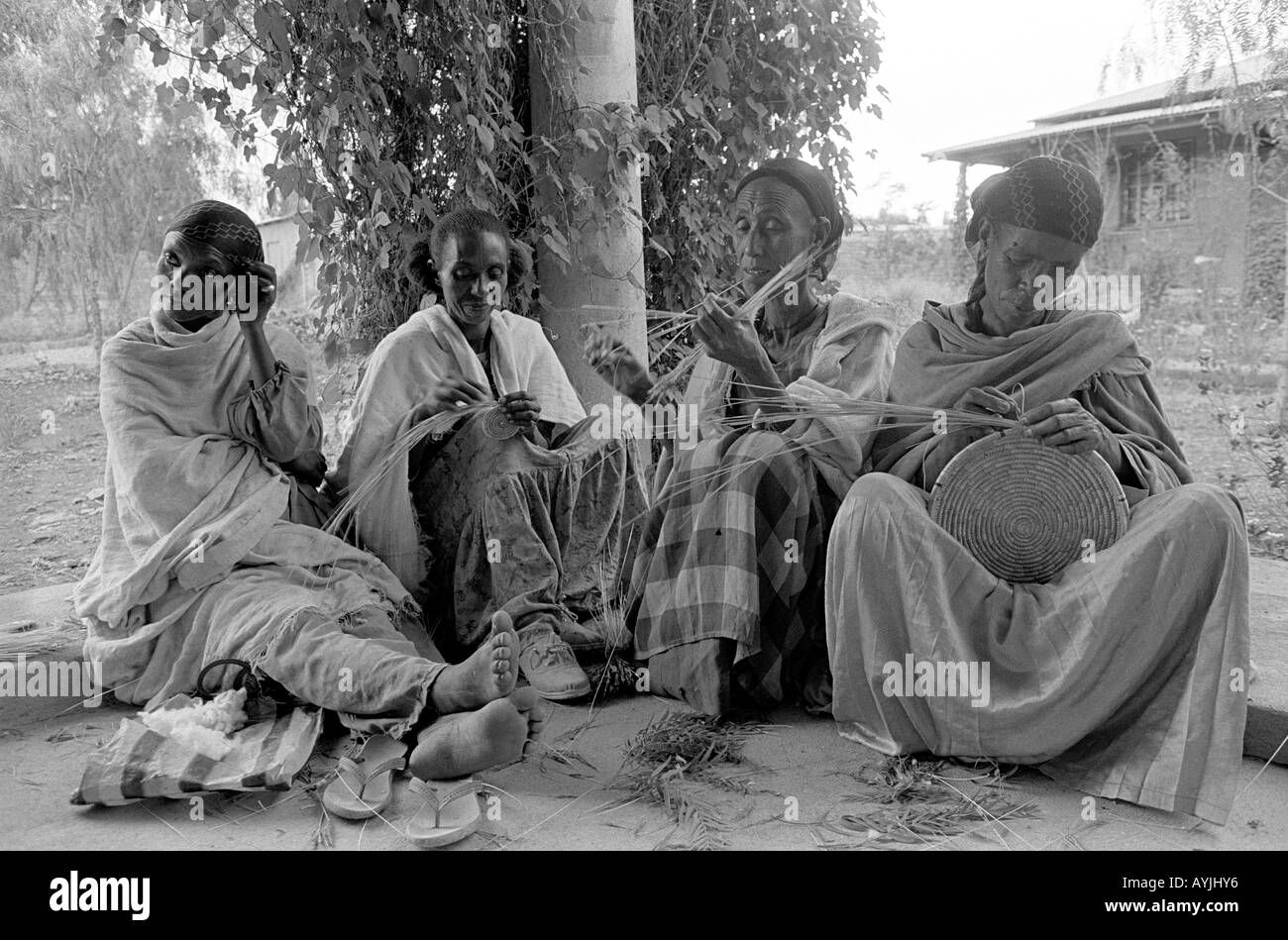 B/W de cuatro mujeres indigentes haciendo canastas sobre un plan de generación de ingresos en un centro de mujeres. Mekelle, Tigray, Etiopía, África Foto de stock