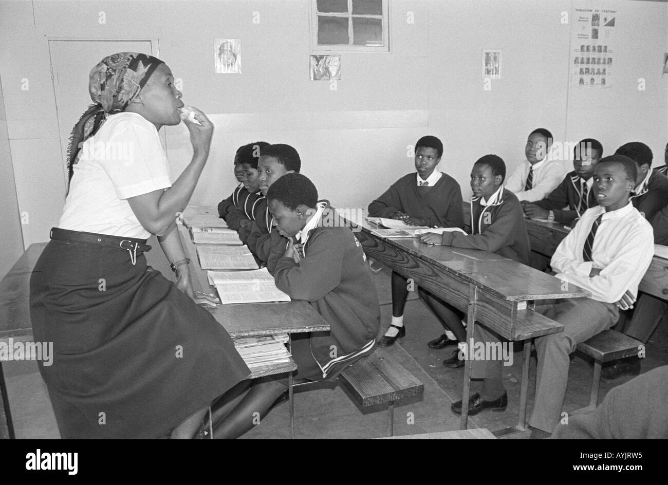 B/N de un maestro y alumnos en un aula de una escuela secundaria rural. Lesoto Foto de stock