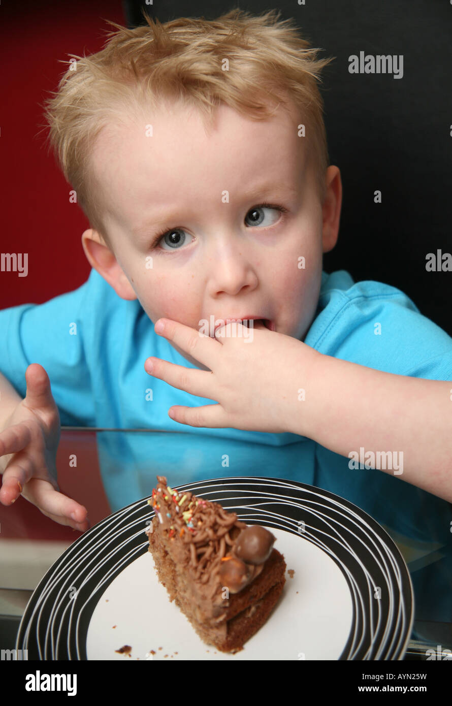 Niño comiendo pastel Fotografía de stock - Alamy