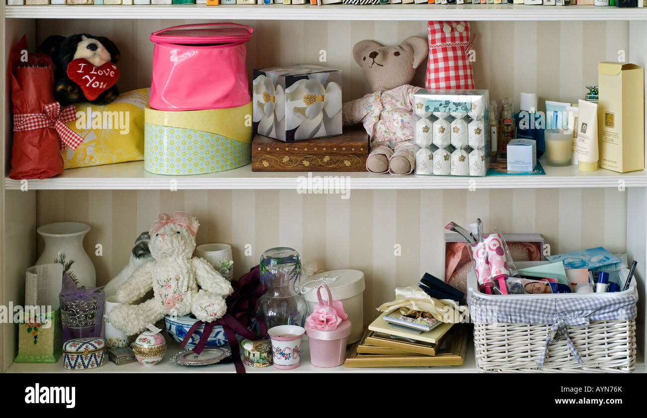 Dos estantes en niñas dormitorio con juguetes blandos bastante cajas y frascos de perfume Foto de stock
