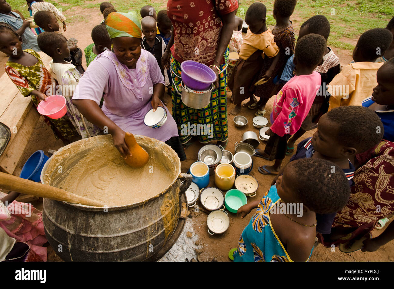 Las mujeres servir el almuerzo para los niños de la escuela primaria Nyologu fuera de la escuela en el pueblo de Ghana septentrional Nyologu Foto de stock