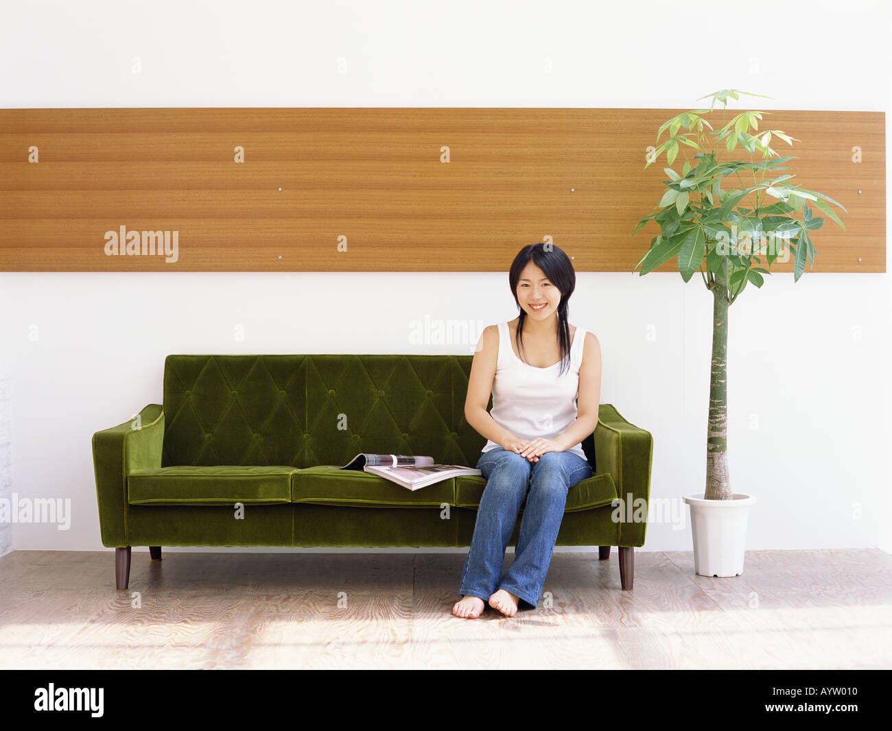 Mujer sentada en un sofá Foto de stock