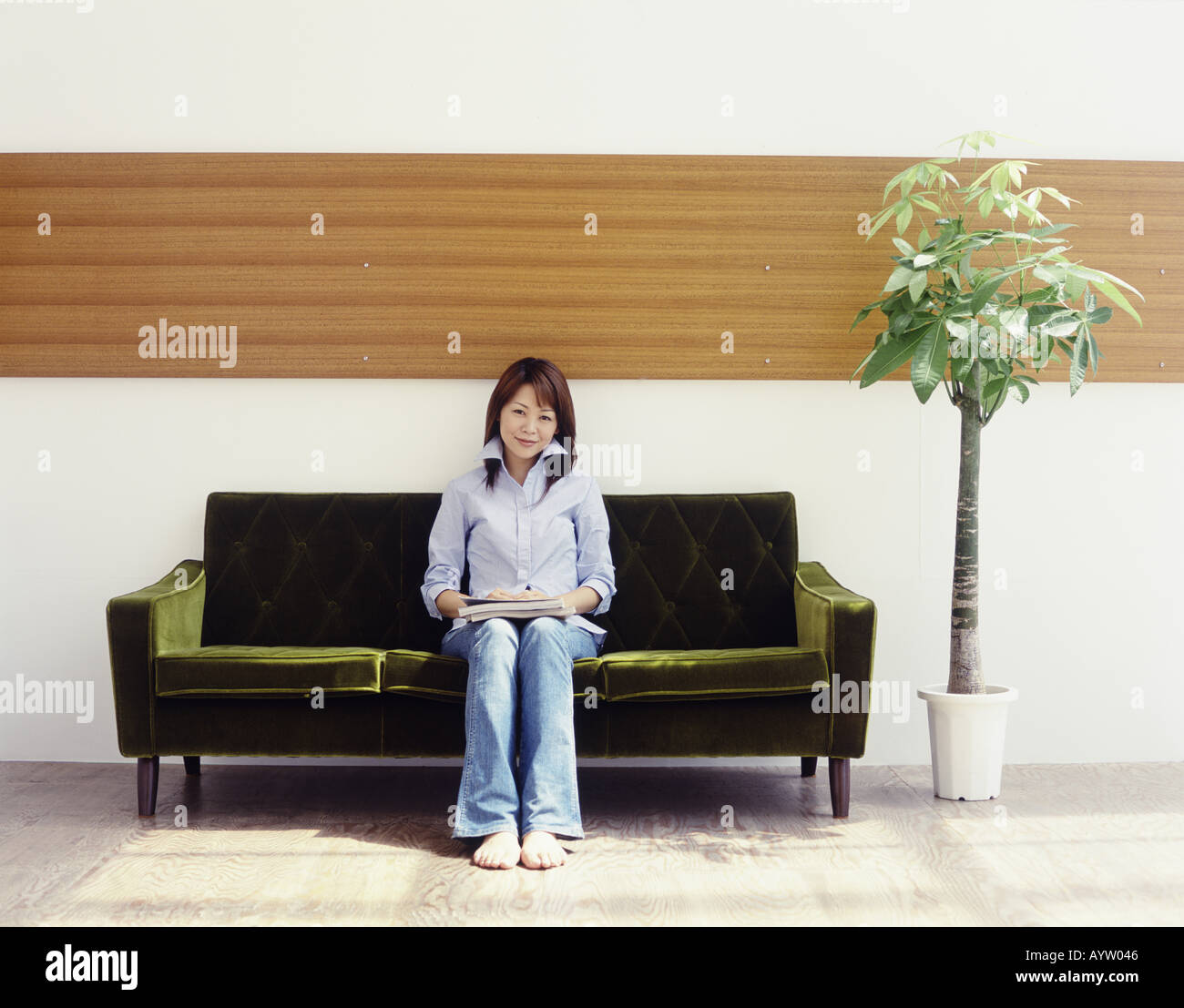 Mujer sentada en un sofá Foto de stock