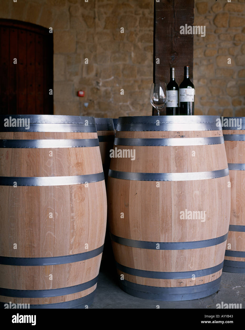 Botellas de Muga Reserva y Torre Muga en la parte superior de nuevos barriles de vino en Bodegas Muga Haro La Rioja España Foto de stock