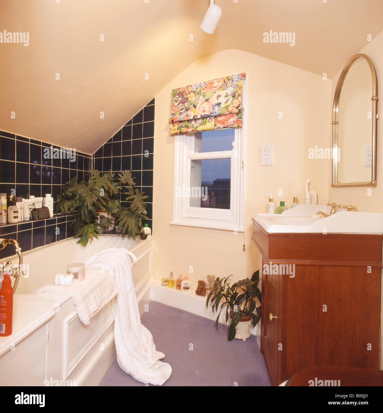Ventana de guillotina a ciegas a floral en ochenta buhardilla baño con  azulejos negros sobre la bañera Fotografía de stock - Alamy