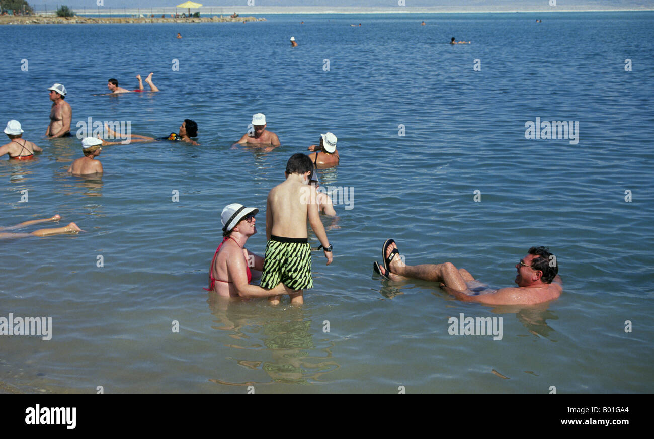 Visitantes alemanes nadar en el agua saturada de minerales del Mar Muerto en un resort en el Gran Valle del Rift Foto de stock