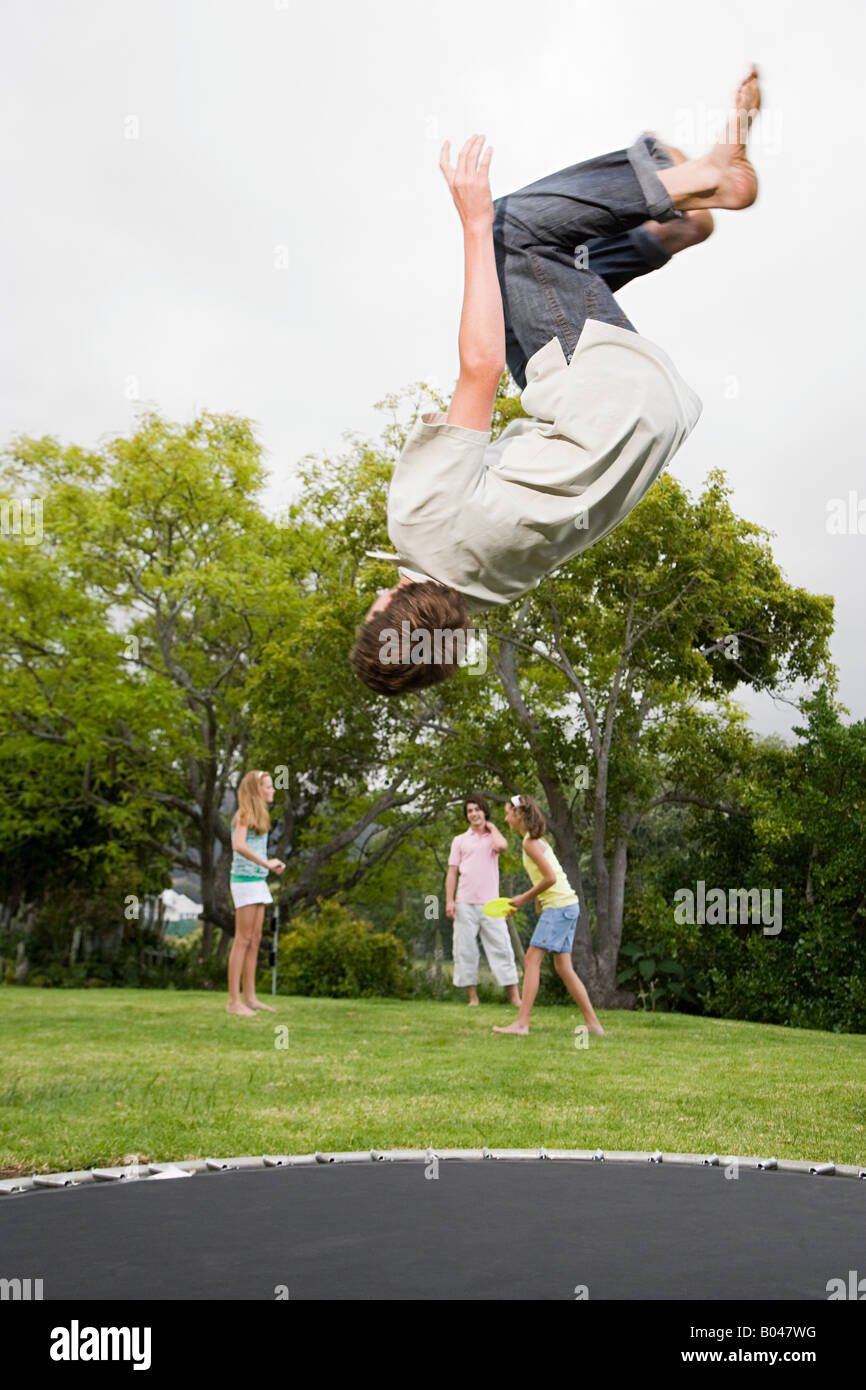 Un adolescente haciendo saltos mortales en una cama elástica Fotografía de  stock - Alamy
