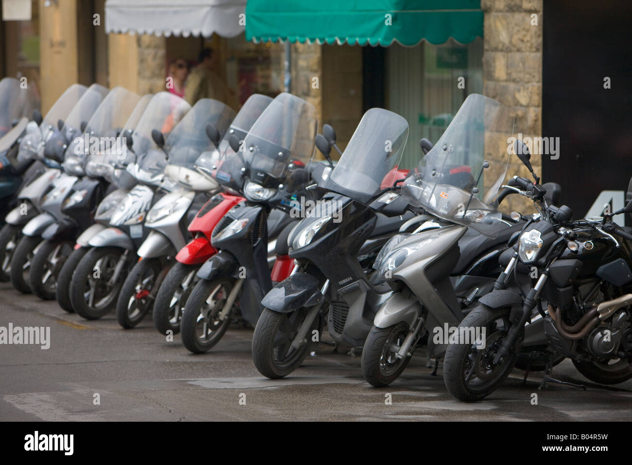 Fila de motos (un modo popular de transporte) que recubre la acera en la ciudad de Florencia, un sitio del Patrimonio Mundial de la UNESCO Foto de stock