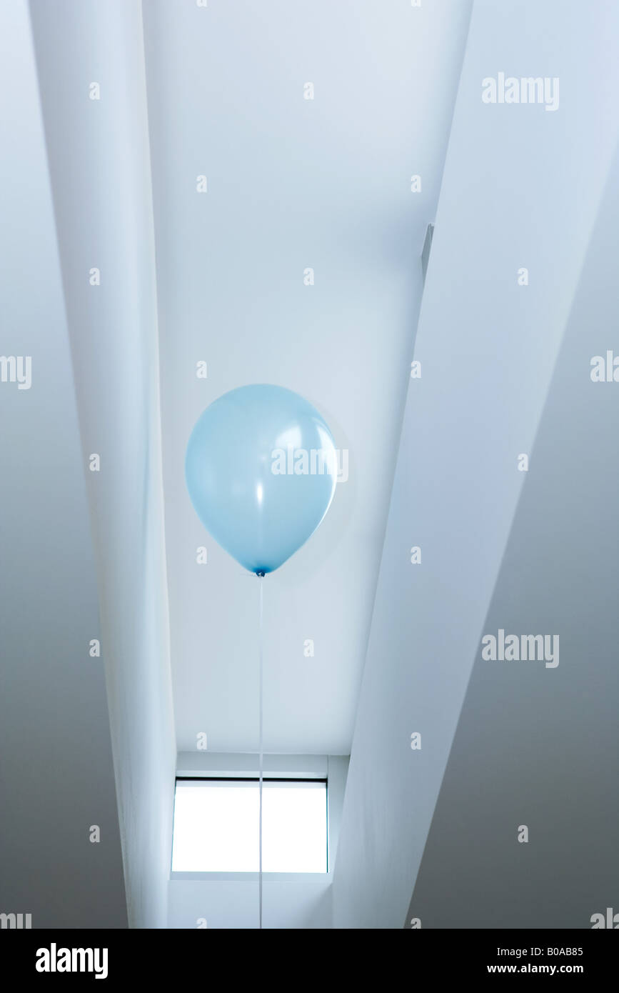 Globo flotando cerca contra el techo, vista de ángulo bajo Foto de stock