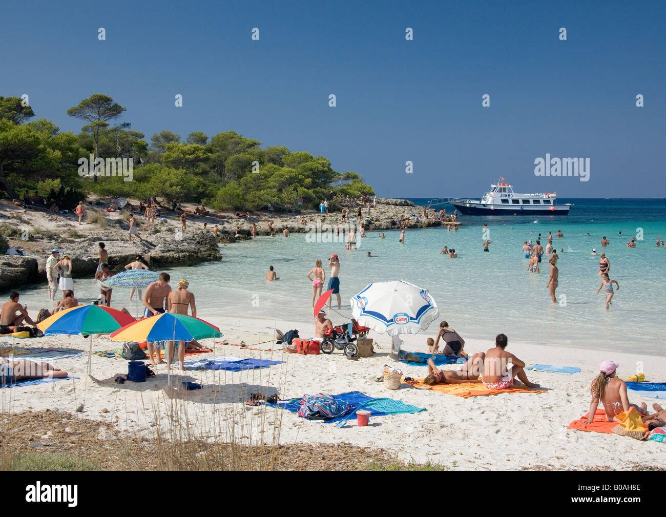 Los veraneantes disfrutando del sol, playa y mar cristalino en el Arenal de Son Saura, Menorca, Islas Ballearic, España. Foto de stock