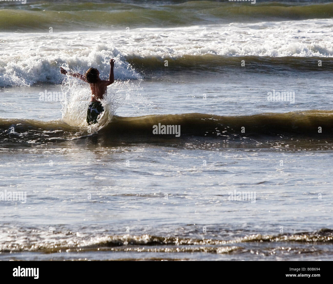 Siluetas de un niño que juega en el océano, en Mazatlán, Sinaloa, México Foto de stock