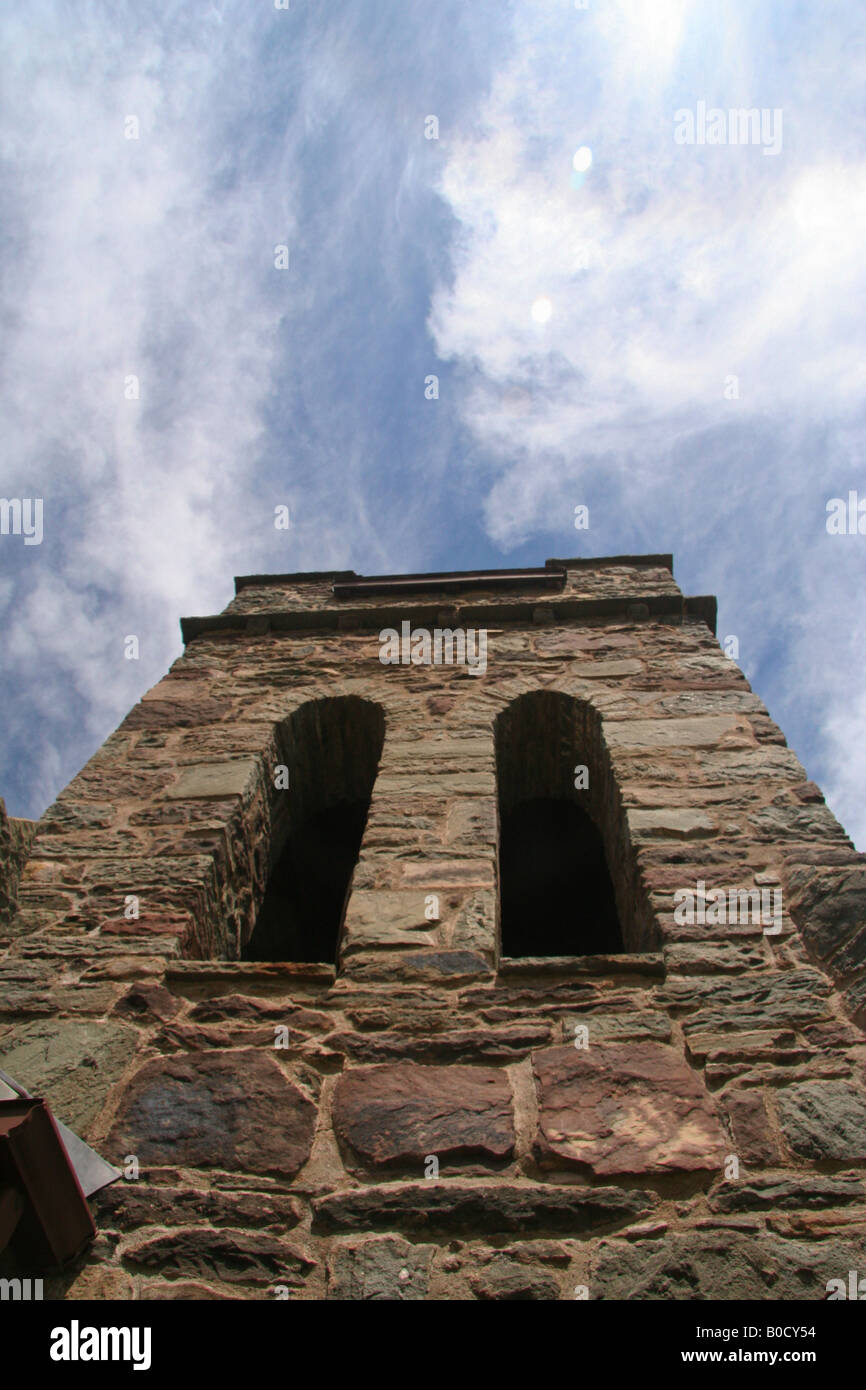 Todas las almas de la torre de la iglesia enmarcado contra el cielo azul con nubes de onteora park en las montañas Catskill de nueva york Foto de stock