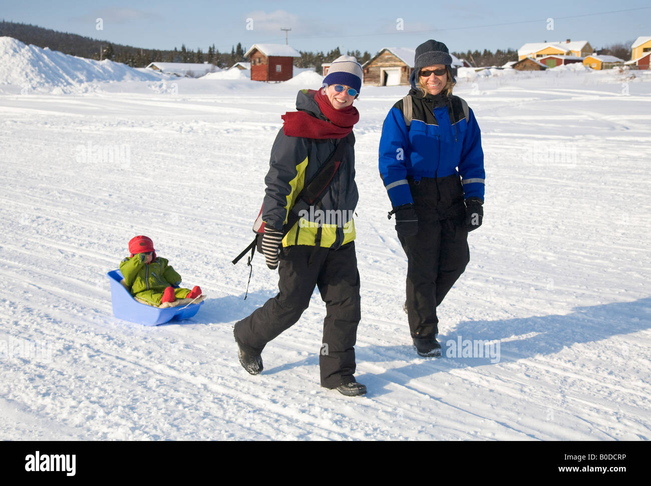 Dos mujeres y una niña en una caminata en la nieve en el norte de Suecia Foto de stock
