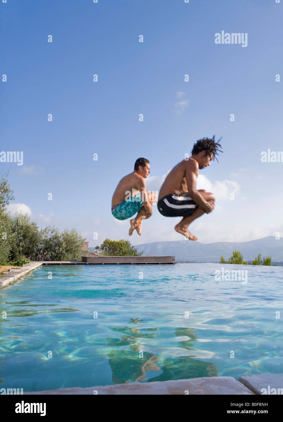 Jóvenes saltando en una piscina Foto de stock