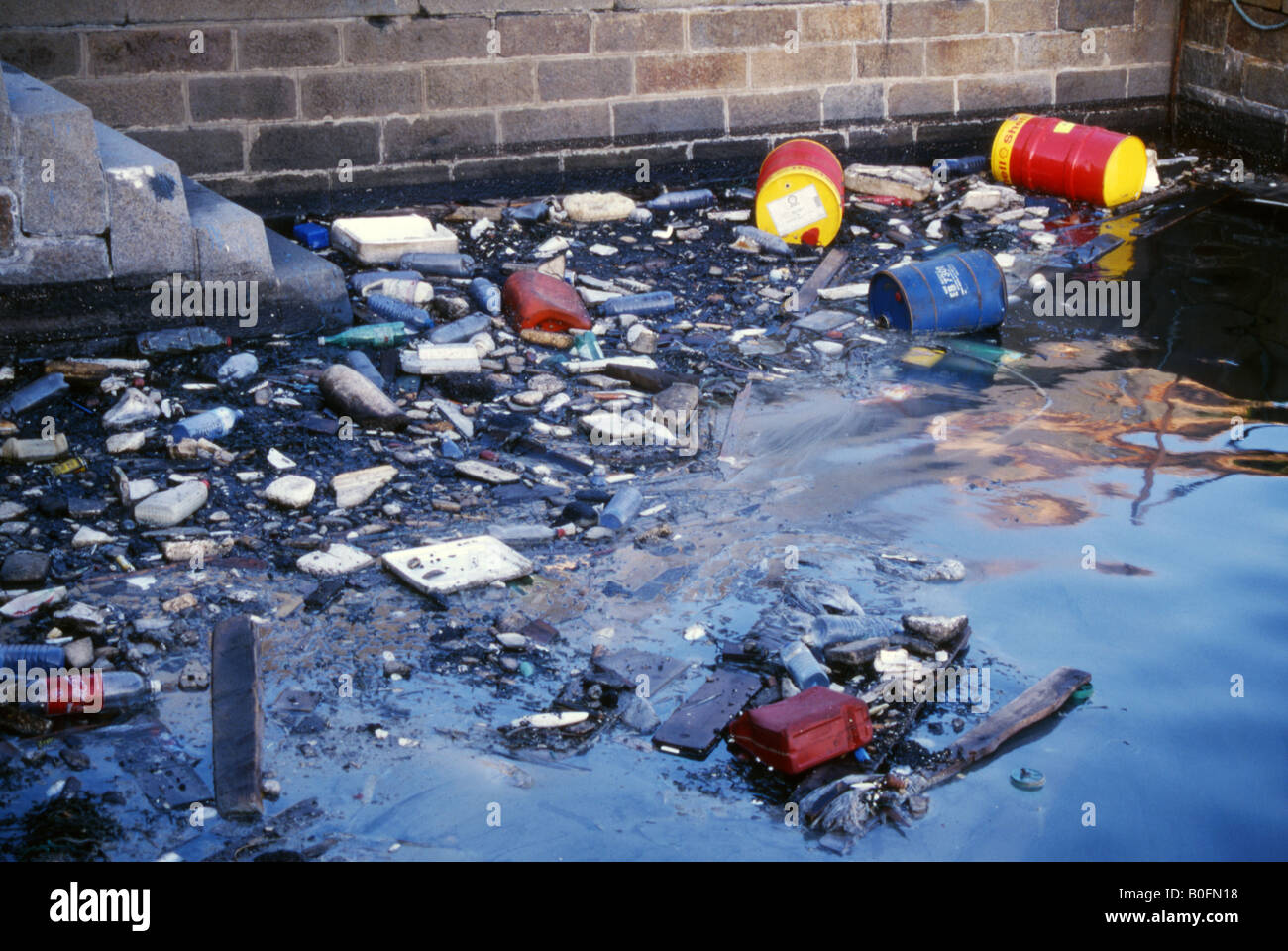 Descarta los bidones de aceite y basura contaminen el agua en el puerto de Portsmouth Inglaterra Foto de stock