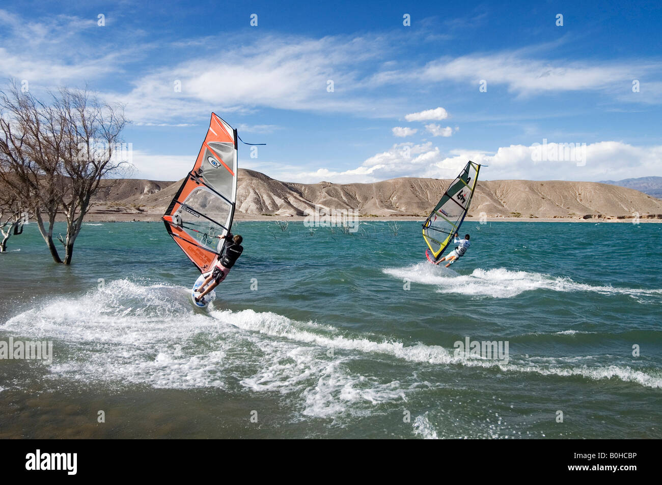 Dos windsurf navegando a alta velocidad a través del windswept presa en Cuesta del Viento, Rodeo, Provincia de San Juan, Argentina, al sur Foto de stock