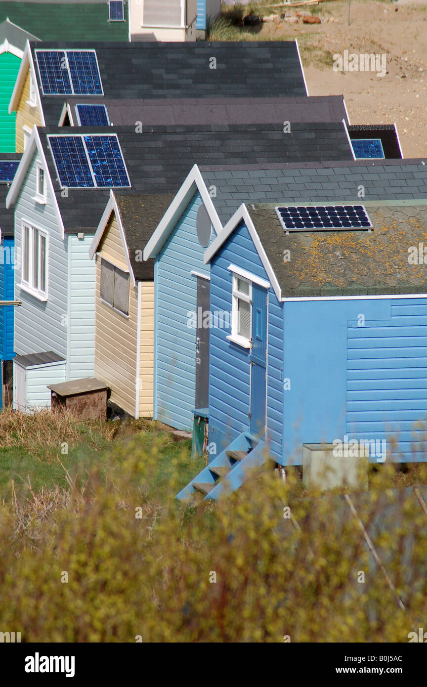 Paneles solares en cabañas de playa en cerca de Mudeford Hengistbury Head en Dorset, Inglaterra Gran Bretaña reino unido renovables de energía verde Foto de stock