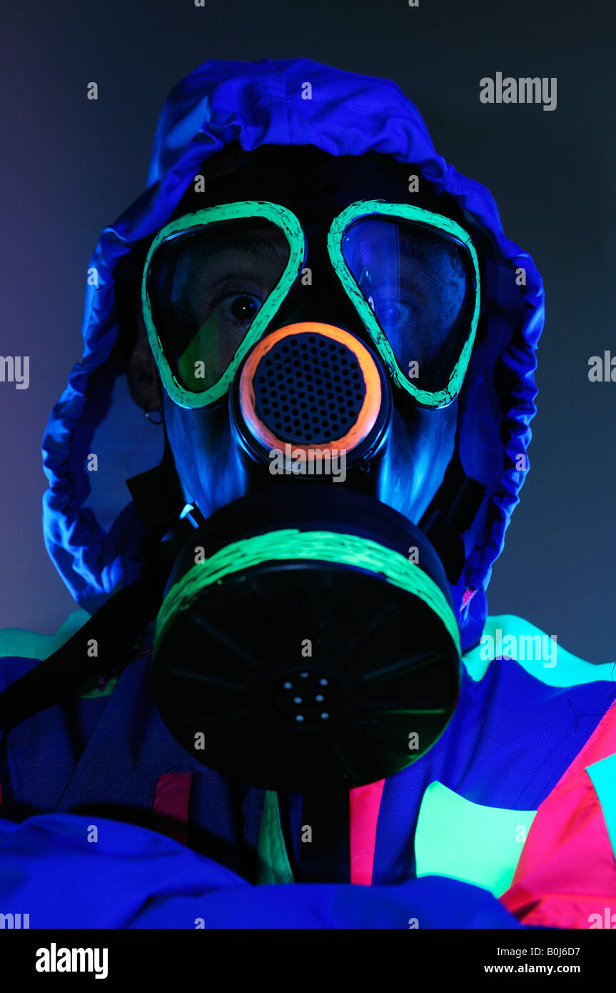 Preocupa al hombre de la máscara de gas fluorescente ropa bajo las luces  negras para materiales peligrosos Fotografía de stock - Alamy
