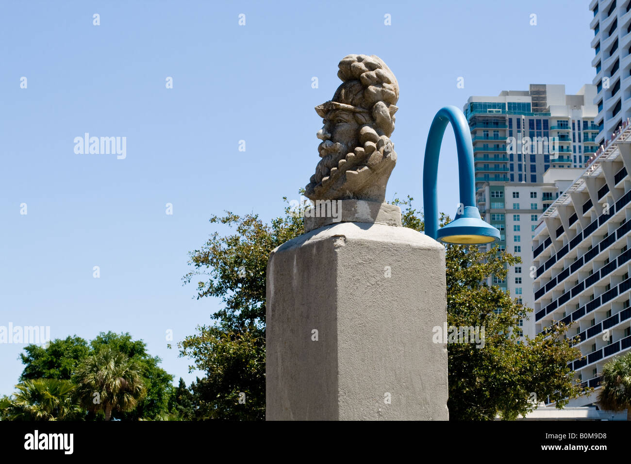 Busto de piedra de Ponce De León sobre pilotes de cemento con un rascacielos en el fondo en Jacksonville, Florida Foto de stock