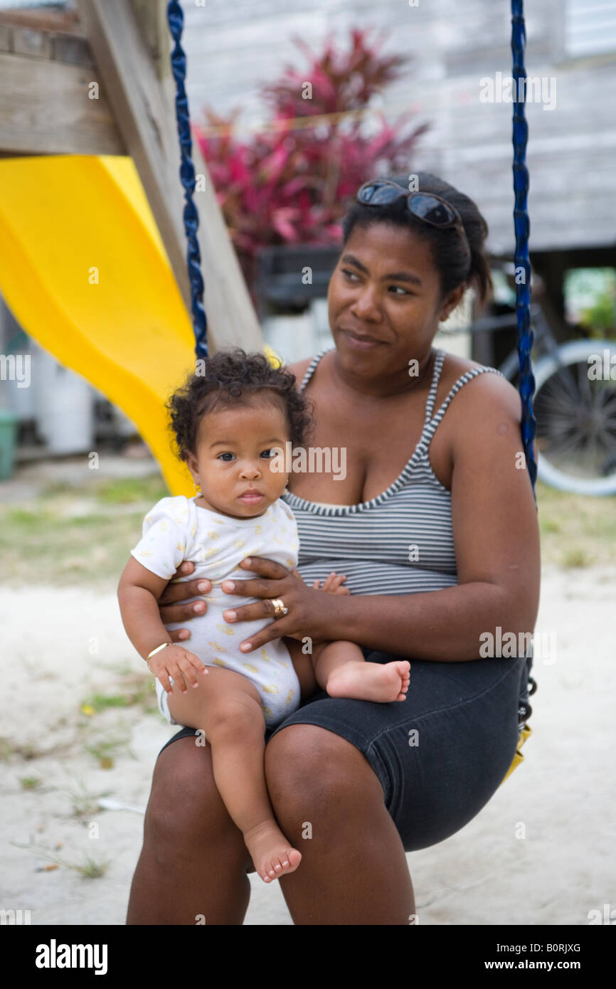 Mujer Belizian en un columpio con su beb en su regazo justo en