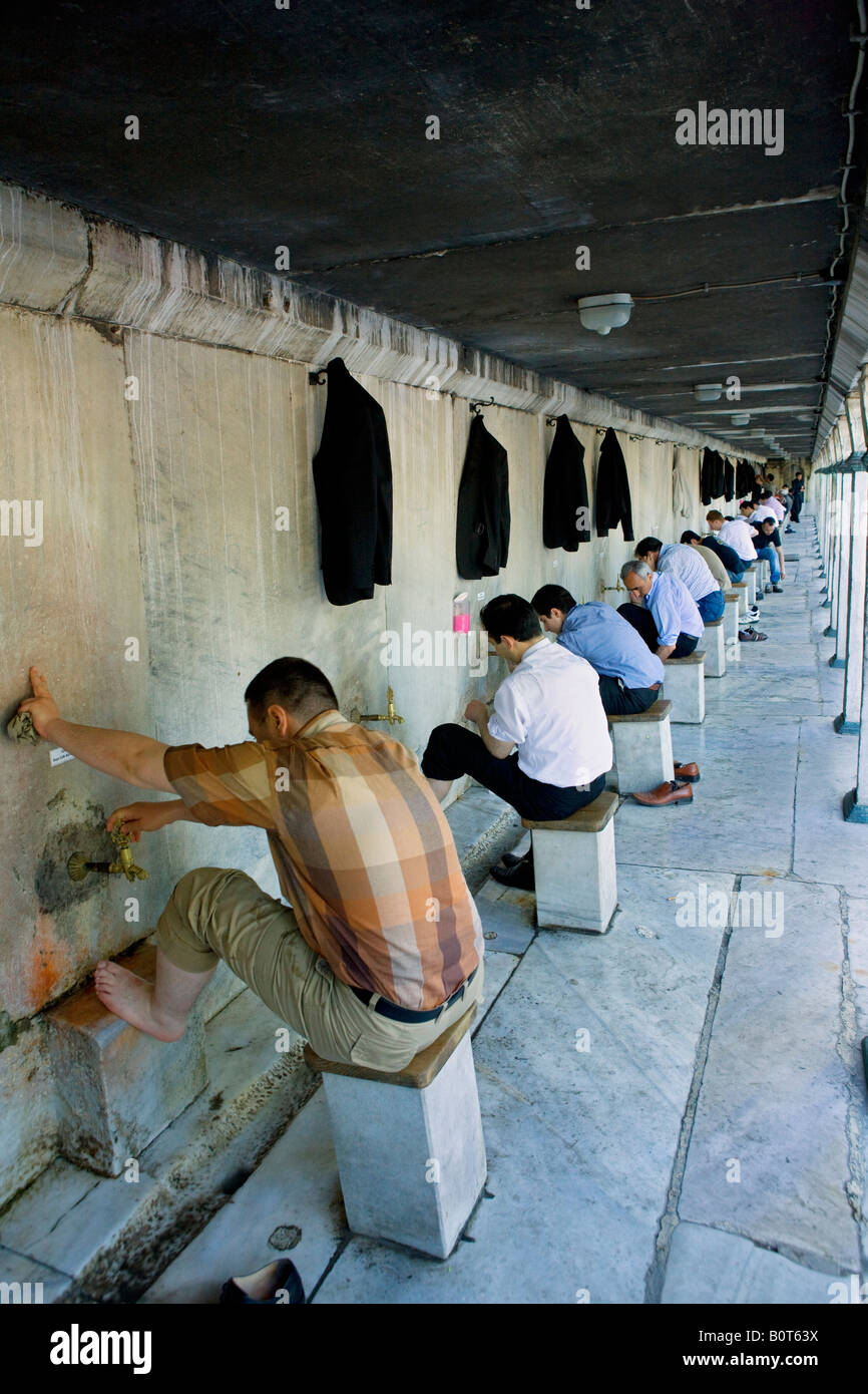 Los hombres musulmanes lavando sus pies antes de entrar en la mezquita Azul de Estambul en la oración Foto de stock