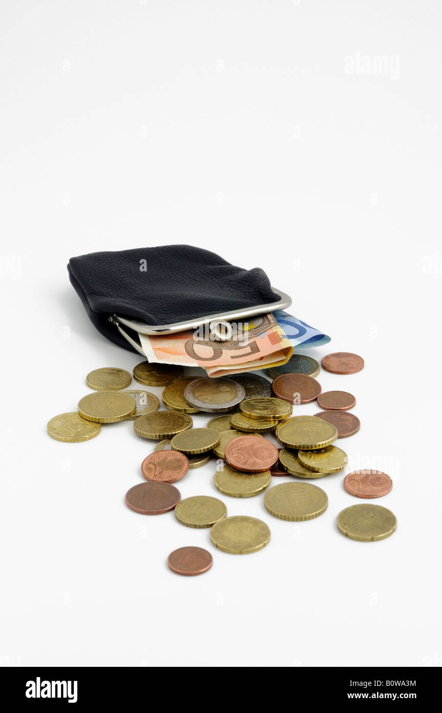 Monedero de cuero llena de monedas y billetes en euros, facturas Foto de stock